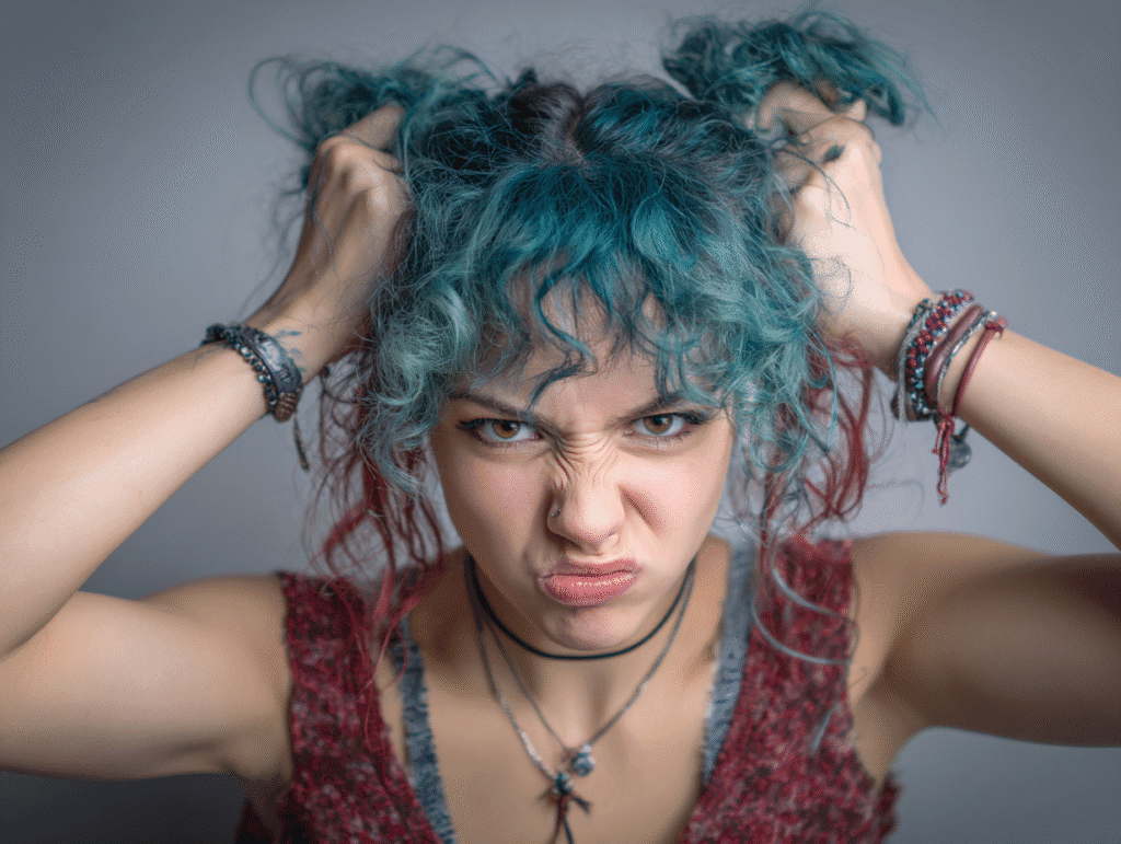 Angry alt woman pulling her hair in frustration, symbolizing emotional tension and the need for control and calibration in social dynamics