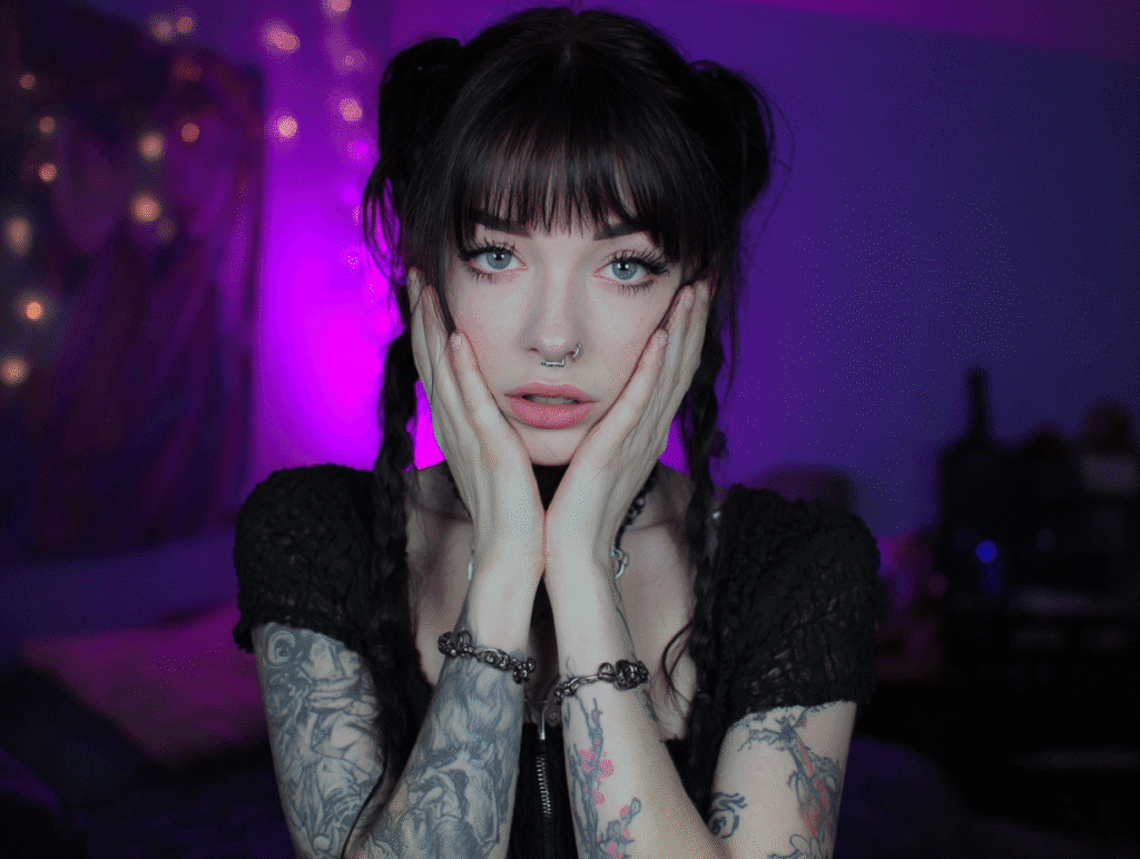 Alt woman with tattoos holding her face in tension, symbolizing emotional and psychological pressure
